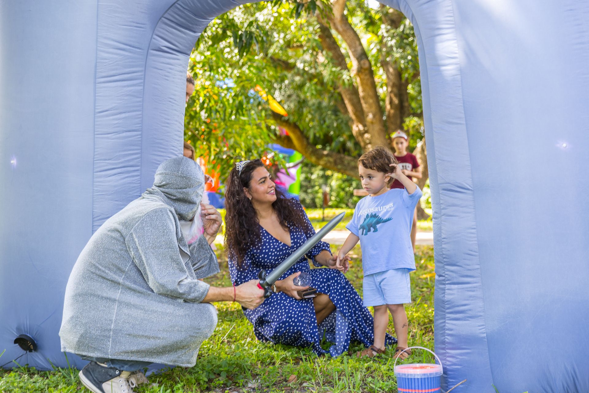 The wizard kneels to talk with a mother and her son
